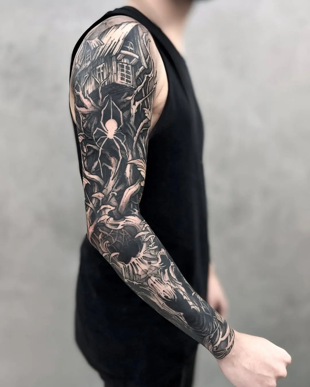Fechamento de braço blackwork com casa mal-assombrada, aranha e árvores secas