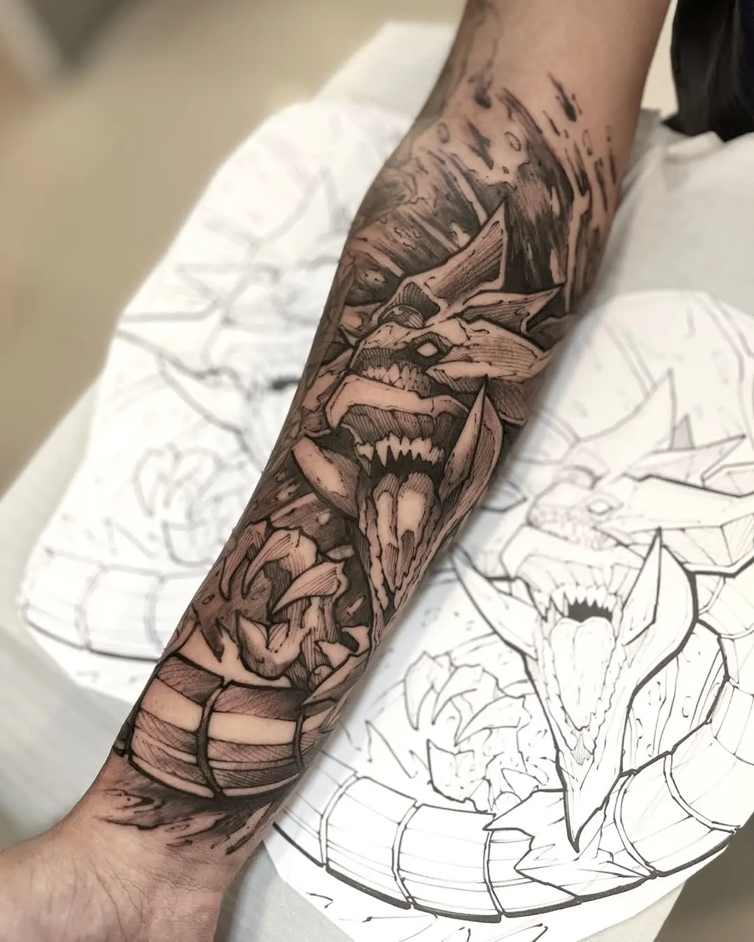 Tatuagem blackwork de criatura fantástica com garras e presas no antebraço